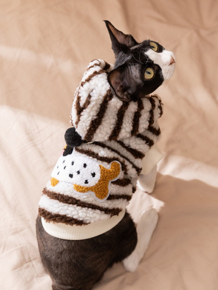 Sphynx cat wearing a brown and white striped sherpa fleece hoodie with appliqué detail on the back.