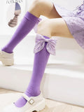 Purple knee-high socks with large decorative bows adorned with pearl-like accents on the calf.