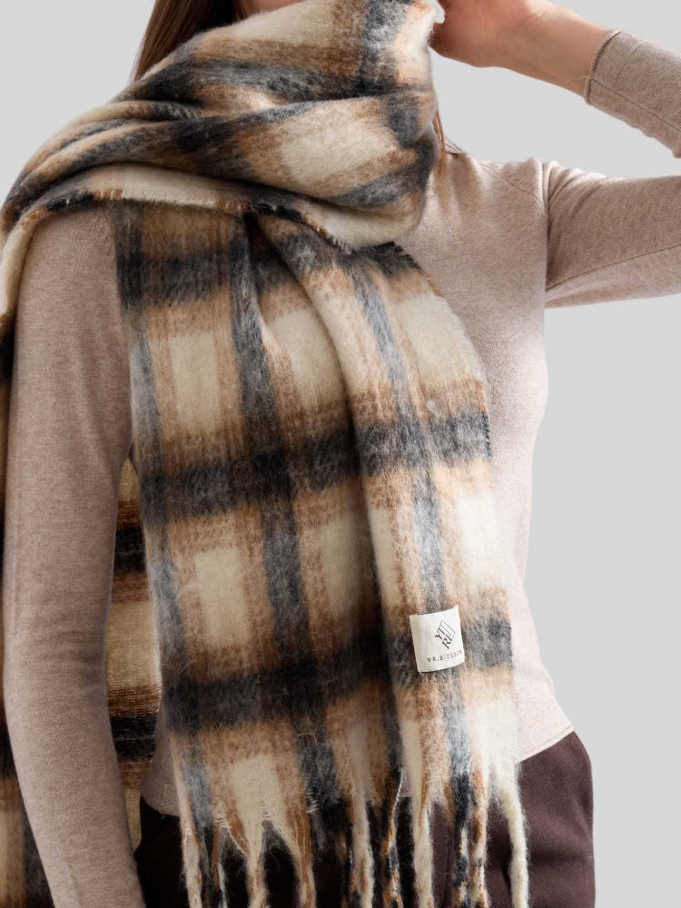 Model showcasing a cozy plaid scarf with fringe