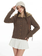 Close-up of the brown cable knit cardigan with wooden button details.