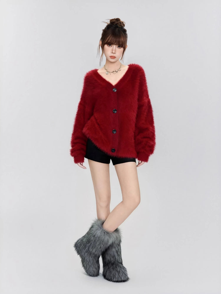 Full body shot of a woman wearing a red fluffy knit cardigan and black shorts.