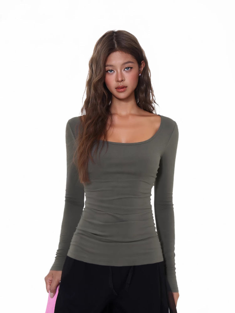 Close-up of a woman wearing a fitted, long-sleeve gray ribbed top with a scoop neckline.