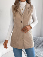 Close-up of the button detail on a beige corduroy longline vest.