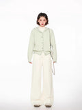 Front view of a woman showcasing a light green hooded knit cardigan with button closure.