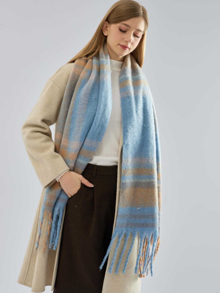 woman in a beige coat with a blue and tan plaid scarf