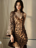 Woman in a leopard print satin slip dress and robe with spaghetti straps.