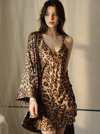 Woman in a leopard print satin slip dress and robe with spaghetti straps.