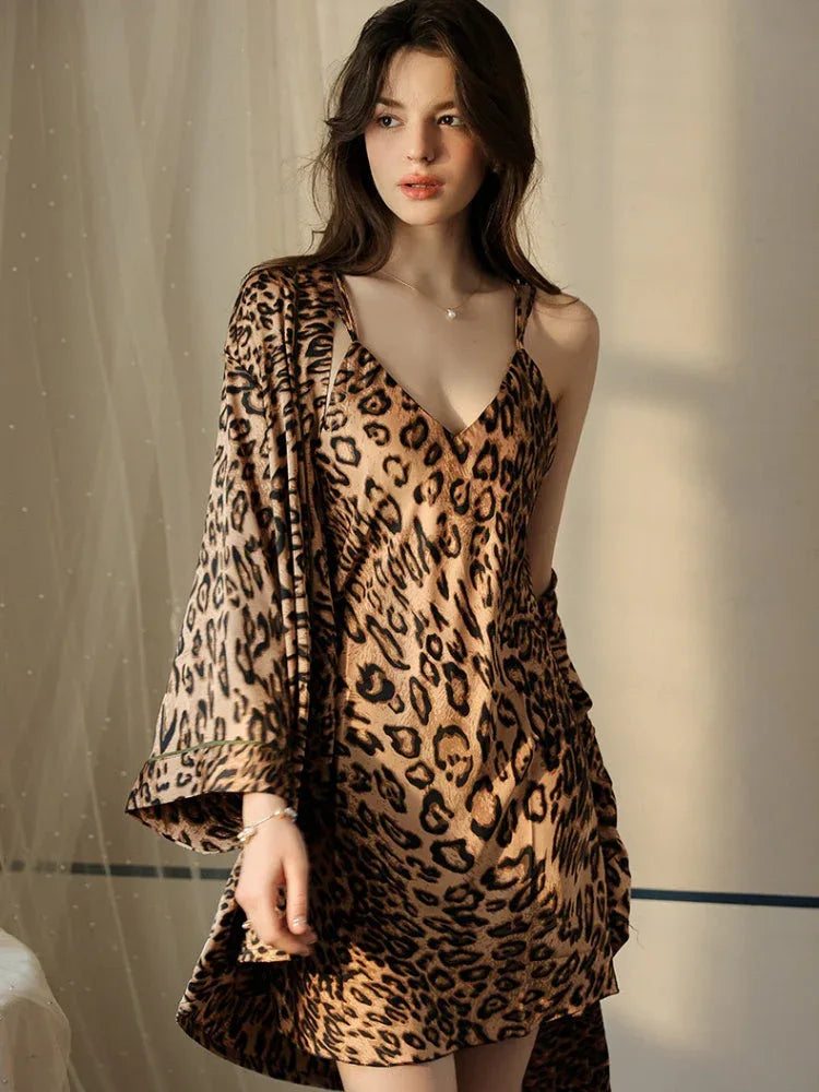 Woman in a leopard print satin slip dress and robe with spaghetti straps.