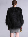 Back view of a woman wearing a black faux fur jacket and grey dress