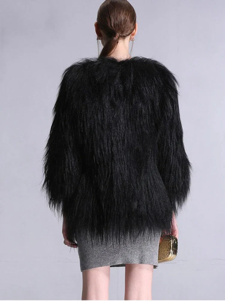 Back view of a woman wearing a black faux fur jacket and grey dress