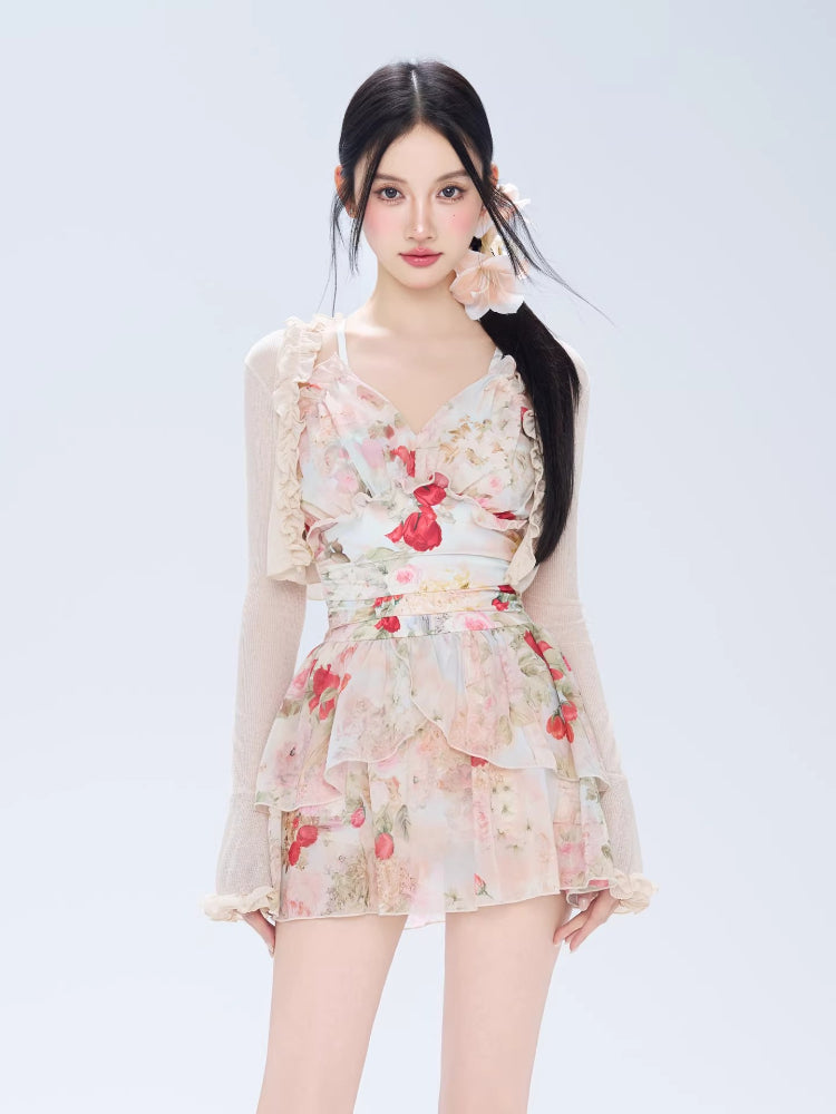 Woman wearing a floral print tiered dress with ruffle trim and a sheer cardigan.