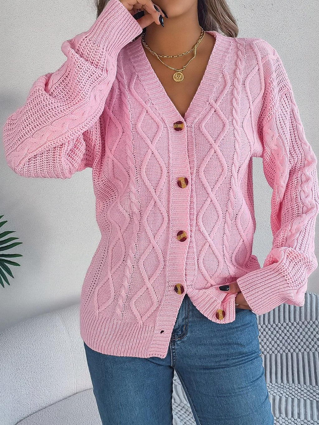 Woman adjusting her pink cable knit cardigan