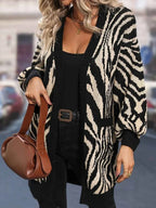 Close-up of a woman wearing a zebra print open-front cardigan.