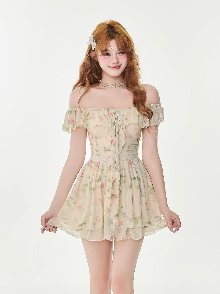 Woman wearing a cream floral print chiffon mini dress with off-the-shoulder ruffle trim and a tie-front detail.