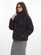 Woman adjusting the scarf on her black puffer jacket