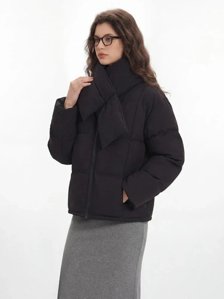 Woman adjusting the scarf on her black puffer jacket