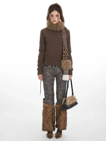 Woman wearing a brown turtleneck sweater, patterned pants with faux fur leg warmers, a leopard print scarf, and a black handbag