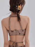 Back view of the halter crop top showing adjustable straps and a sheer mesh fabric with butterfly print.