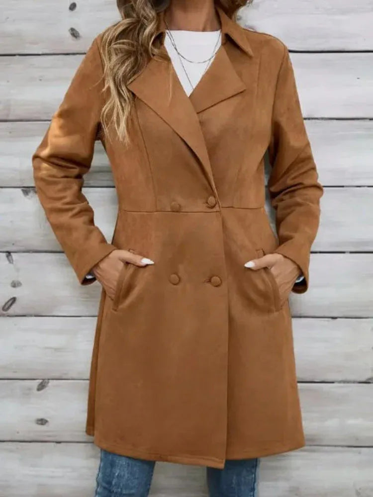 Woman in a brown suede-like coat with her hands in the side pockets.