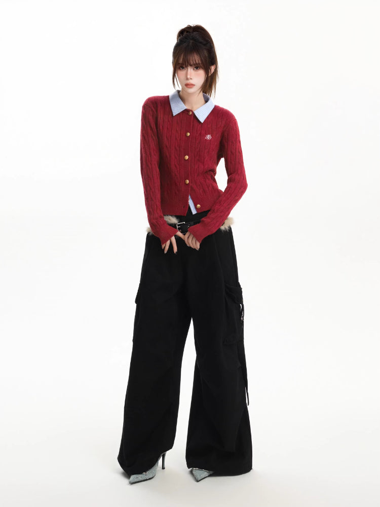 Full body shot of a woman modeling a red cable knit cardigan and black wide-leg pants.