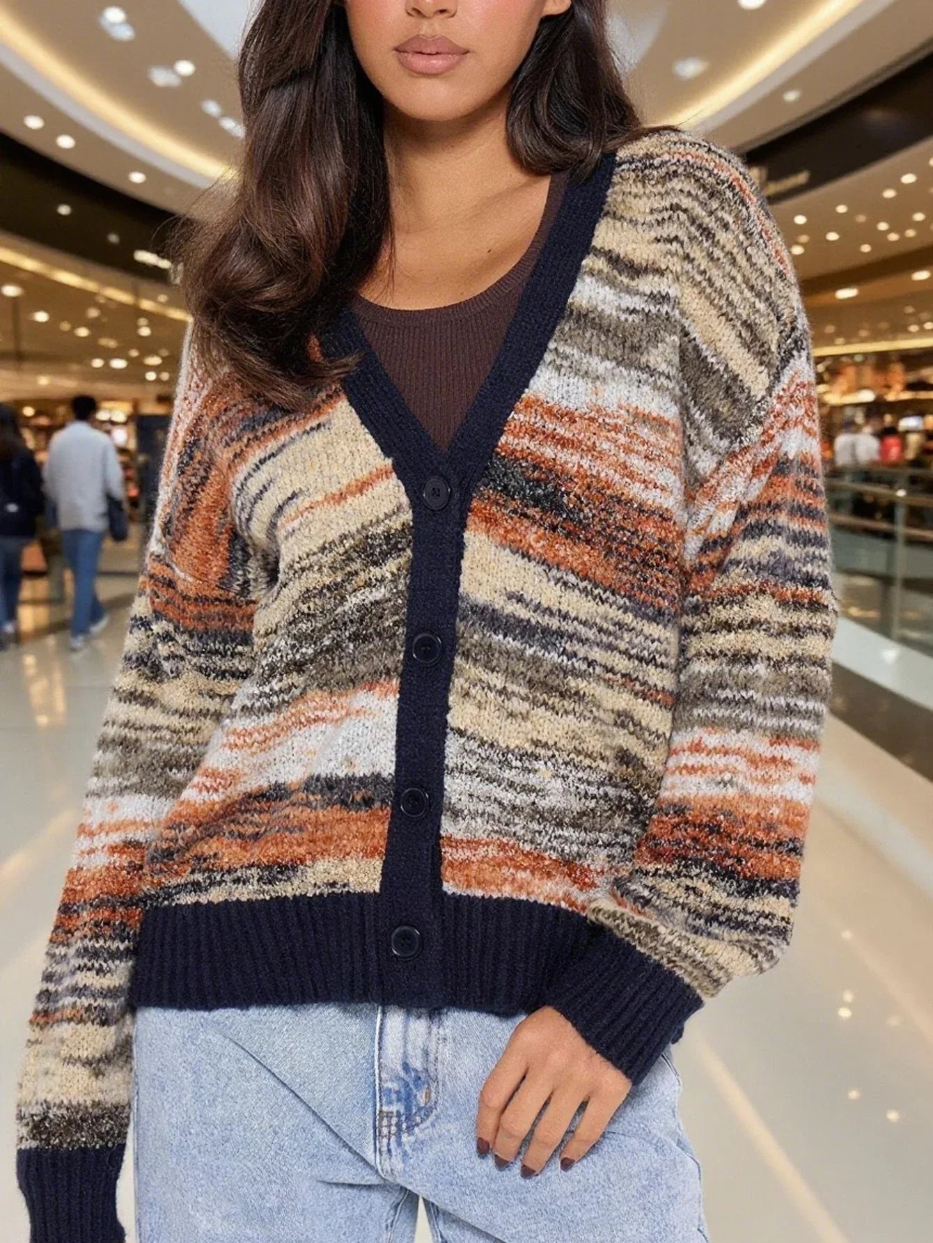 Close-up of a woman wearing a multicolored striped knit cardigan with a V-neck and button-up front