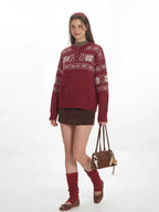 Woman wearing a red knit sweater with a white Fair Isle pattern and a button placket, holding a handbag.