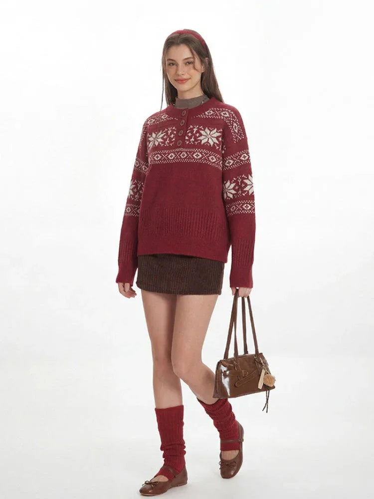 Woman wearing a red knit sweater with a white Fair Isle pattern and a button placket, holding a handbag.