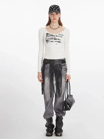 Woman wearing a white long-sleeve graphic t-shirt with a scoop neckline and studded details.