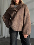 Woman wearing a brown fleece pullover with a stand-up collar and button-up placket.