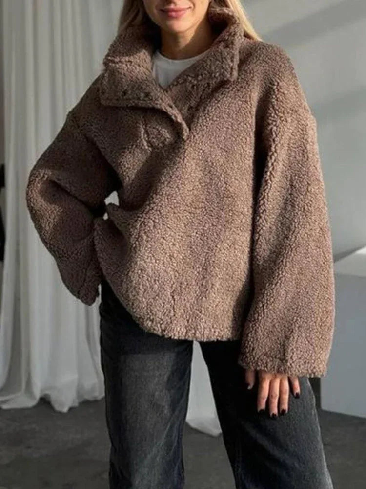 Woman wearing a brown fleece pullover with a stand-up collar and button-up placket.