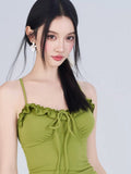 Close-up of the green textured knit mini dress neckline featuring ruffled trim and a tie-front detail.