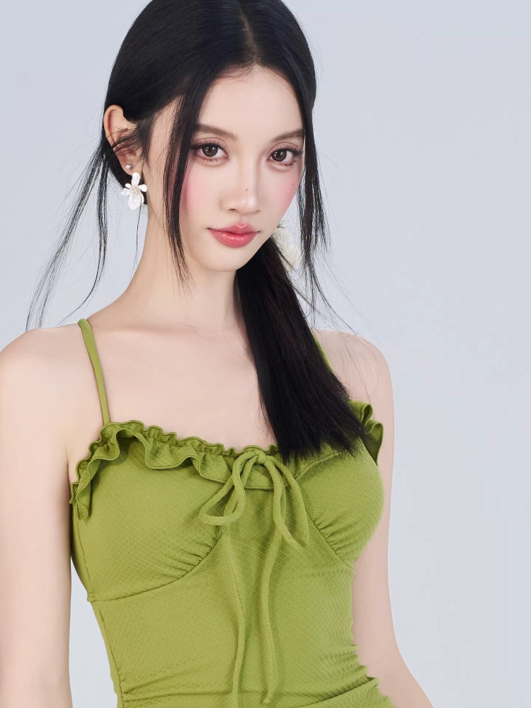 Close-up of the green textured knit mini dress neckline featuring ruffled trim and a tie-front detail.