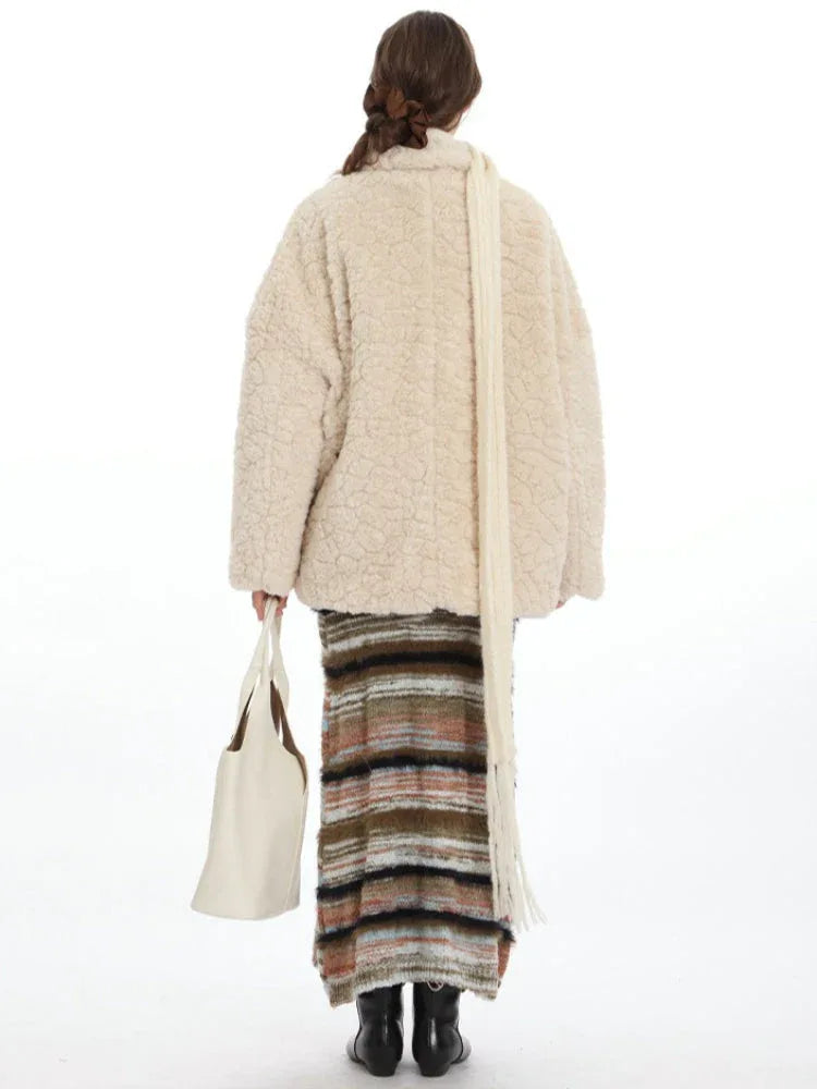 Cream fleece toggle coat with a white scarf and striped skirt