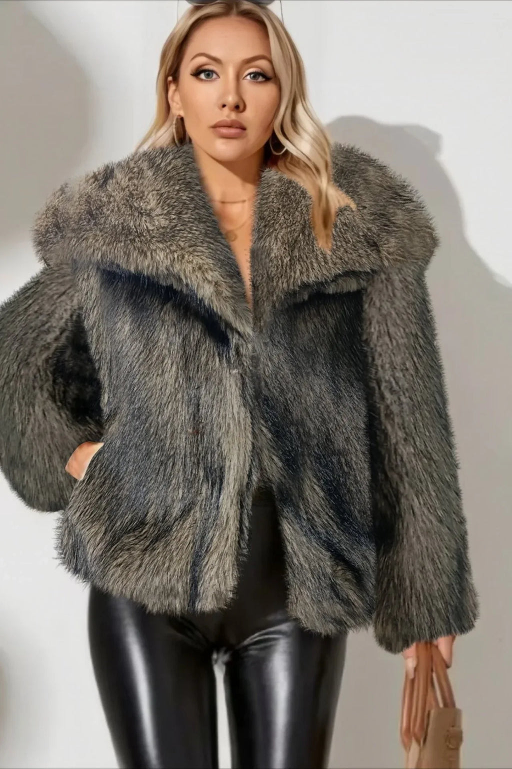 Woman wearing a grey faux fur jacket with a wide collar and leather pants.