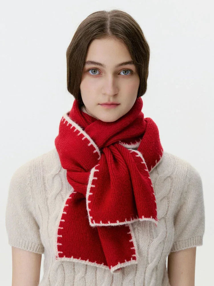 Model wearing a red knit scarf with white contrast stitching