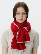 Model wearing a red knit scarf with white contrast stitching