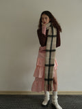Model styled with a plaid scarf and pink tiered skirt