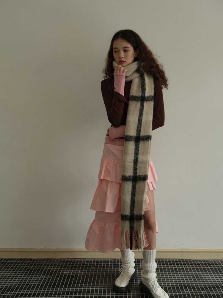 Model styled with a plaid scarf and pink tiered skirt