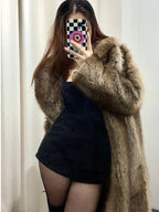 Woman posing in a faux fur coat and black outfit.