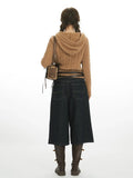 Back view of a woman in a brown hooded cable knit sweater