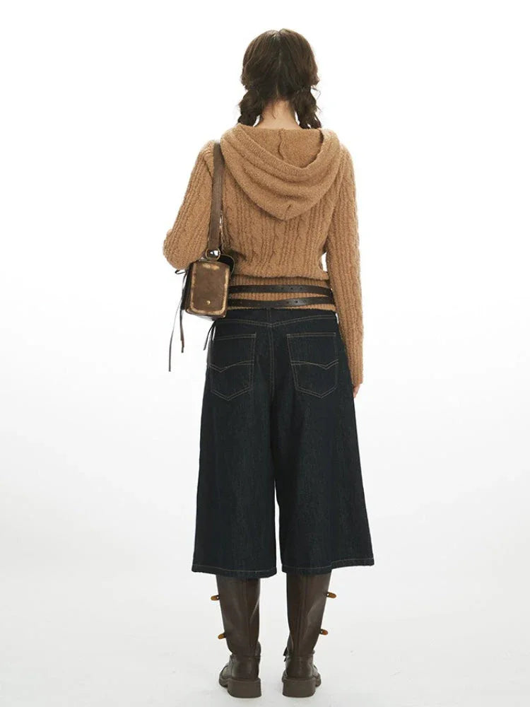 Back view of a woman in a brown hooded cable knit sweater
