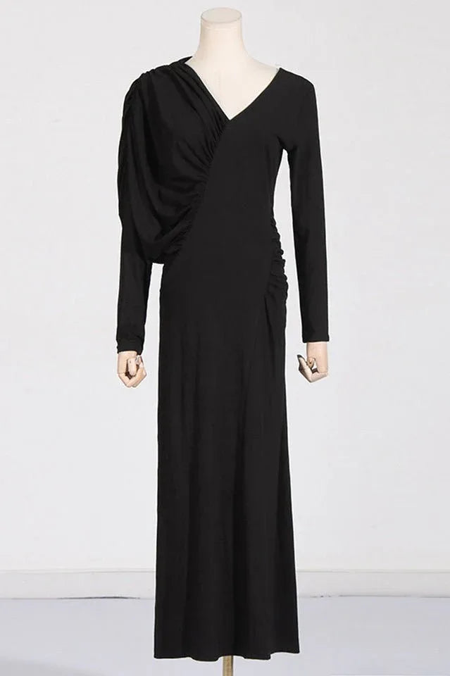 A mannequin wearing a black ruched V-neck dress with long sleeves.