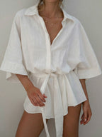 Woman wearing a white linen blend collared short-sleeved top with a tie waist