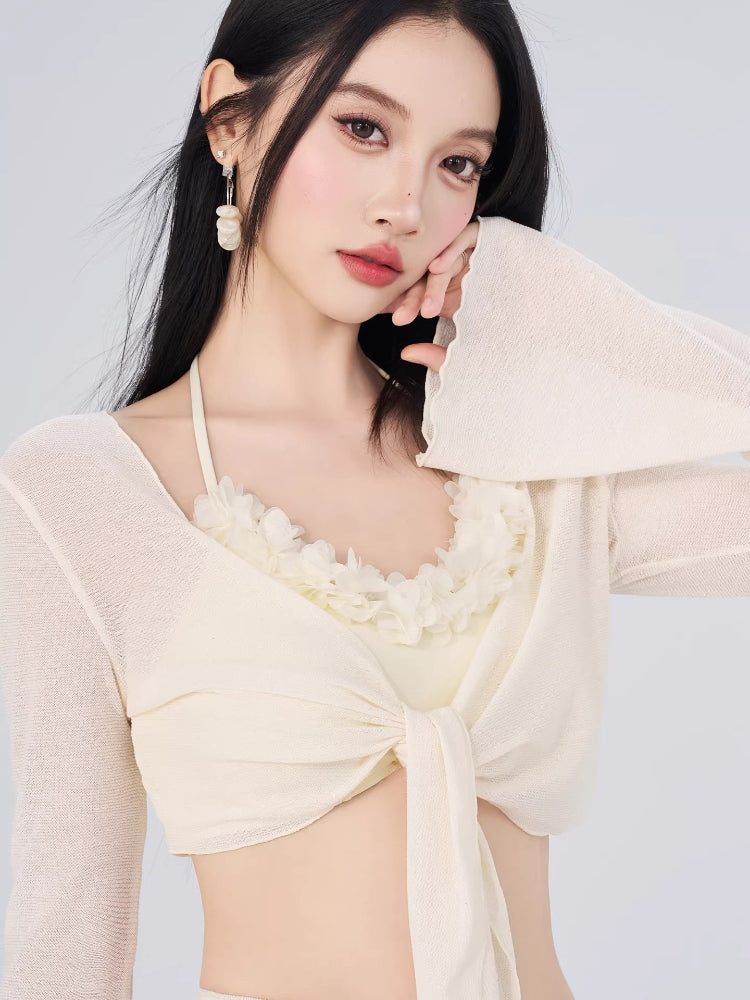 Close-up of the cream-colored sheer cover-up, showing the tie front and ruffled neckline.
