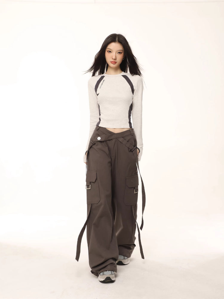 Model wearing a light grey long-sleeve athletic top with dark grey contrasting panels.