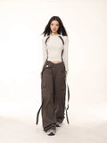Full body shot of a model in a light grey long-sleeve athletic top and dark grey cargo pants.