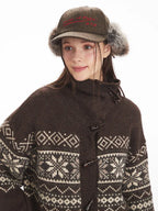 Detail of the toggle closure and pattern on a brown Fair Isle knit cardigan.
