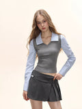 Close-up of a model's upper body showing the grey knit vest layered over a blue striped collared shirt.