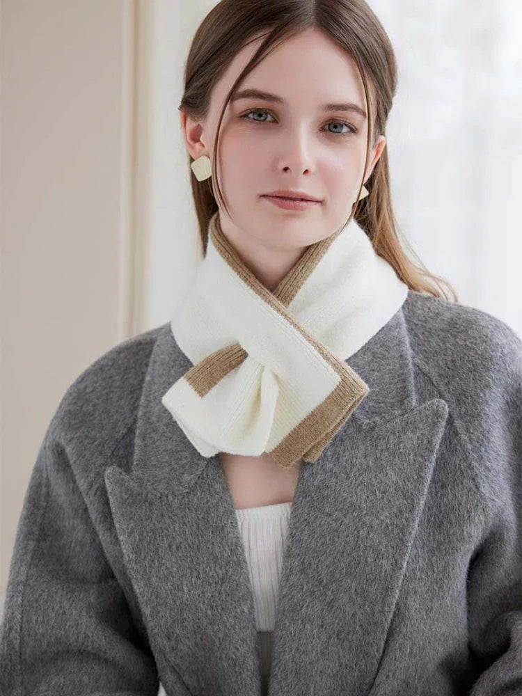 Model showcasing a two-tone knit scarf with a tan and white color block design