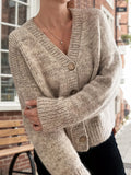 Close-up of a beige knit cardigan with wooden buttons